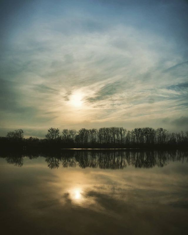 Sun behind clouds reflection